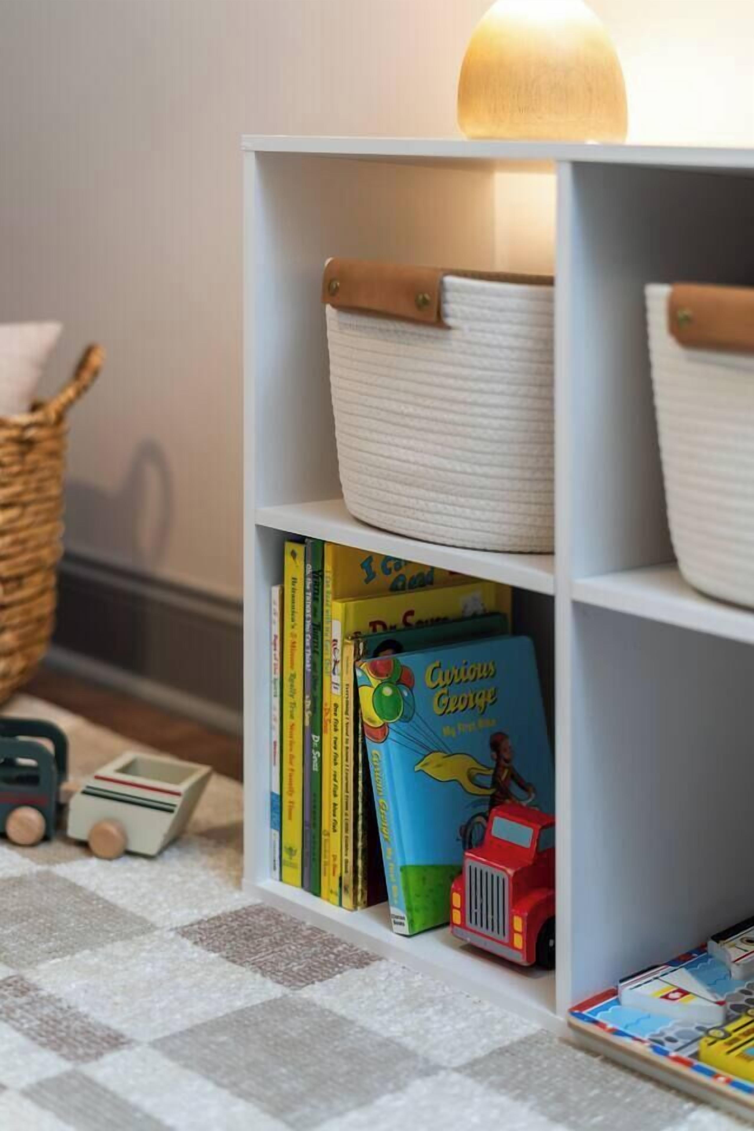 A bookshelf with storage baskets and children's books.