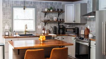 A modern kitchen with a central island, stainless steel appliances, and a window providing natural light.