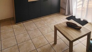 A small, modern kitchen with a microwave, a clock, and a TV mounted on the wall. - T2 beach walk - family relaxation (Linguizzetta)