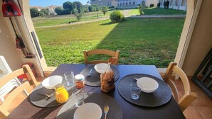 A table set for four with a view of a building and greenery outside. - T2 beach walk - family relaxation (Linguizzetta)