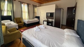 A hotel room with two beds, a desk with a TV, a wardrobe, and a chair. - Grand Bedir (Istanbul)