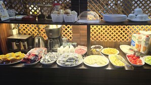 A buffet with various food items and condiments, including fruits, cheeses, and packaged snacks. - Grand Bedir (Istanbul)