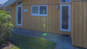 A wooden building with a sloped roof, a door, and a window. - Ferienhaus im Skandinavischen Stil (Rechlin)
