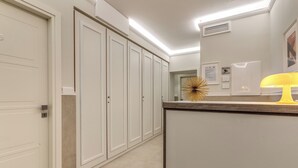 A hallway with white doors, a reception desk, and a wall-mounted air conditioner. - Relais Marco Polo (Rome)