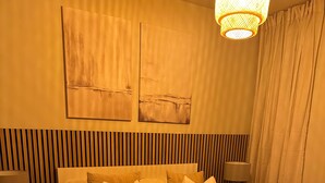 A neatly arranged bedroom with a bed, two bedside tables, and a hanging light fixture. - Renovatedapartmentsleeps4-freeparking-tv (Brentford)