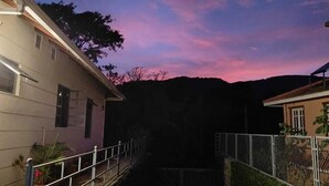 A residential area at dusk with a paved pathway leading to a gated entrance. - Villa #248 (Somvarpet)