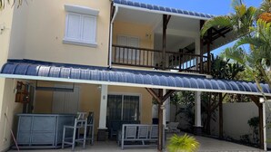 A two-story house with a covered patio, a swimming pool, and outdoor furniture. - Salty Chateau: Private Exquisite Mauritian Getaway (Cap Malheureux)