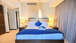 A hotel room with a large bed, two bedside tables, a nightstand, and a window with curtains. - Luxury Marina 1-Bedroom - 5-star Hotel Amenities (Dubai)