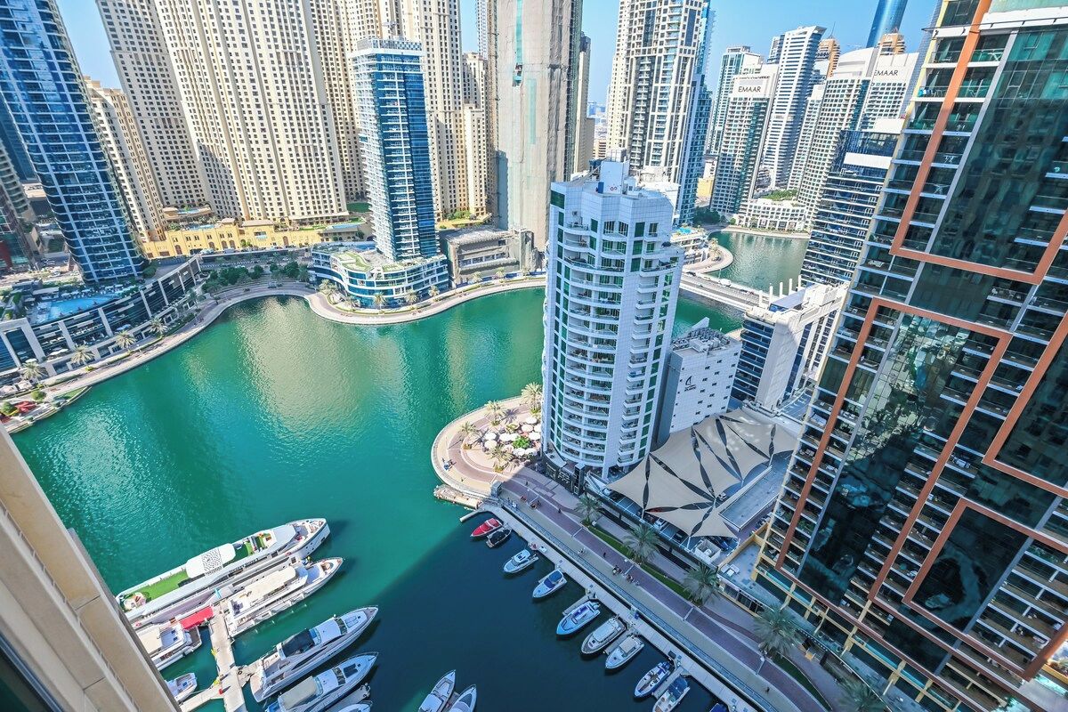A high-rise building with a marina and boats.