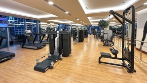 A gym with treadmills, weight machines, and exercise equipment. - Luxury Marina 1-Bedroom - 5-star Hotel Amenities (Dubai)