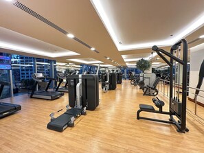 A gym with treadmills, weight machines, and exercise equipment. - Luxury Marina 1-Bedroom - 5-star Hotel Amenities (Dubai)