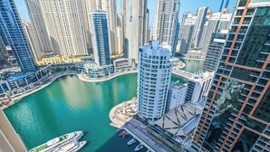 A high-rise building with a marina and boats. - Luxury Marina 1-Bedroom - 5-star Hotel Amenities (Dubai)