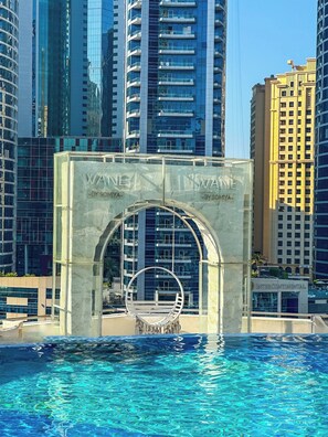 A swimming pool with a clear view of tall buildings in the background. - Luxury Studio - Stunning Marina View, 5-star (Dubai)