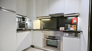 Een moderne keuken met roestvrijstalen apparatuur, waaronder een magnetron, oven en vaatwasser.