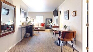 A compact living space with a kitchenette, dining area, and seating. - The Washington Hotel (Port Townsend)