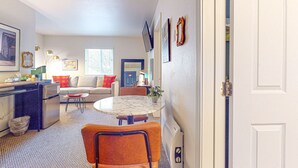 A compact living space with a kitchenette, dining area, and seating. - The Washington Hotel (Port Townsend)