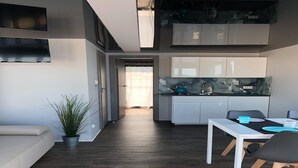 Una cocina moderna con armarios blancos y encimera negra.