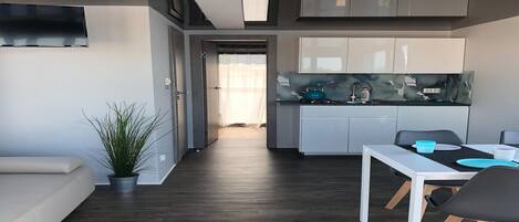 A modern kitchen with white cabinets and a black countertop.
