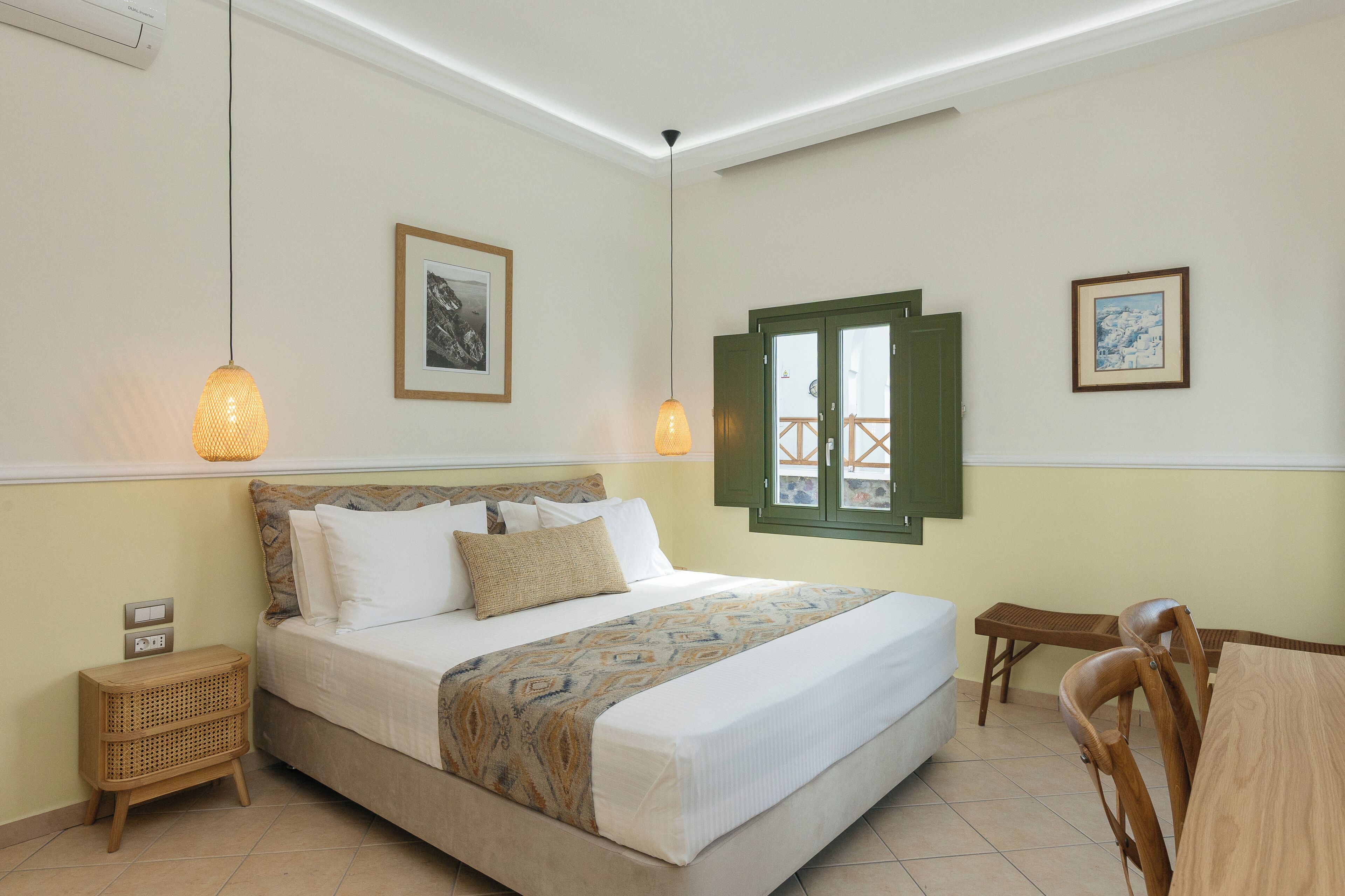 A neatly arranged bedroom with a bed, bedside tables, a wooden chair, and a dining table.