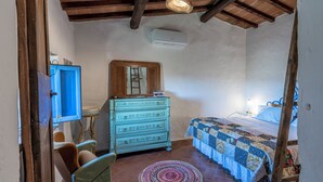 Une chambre à coucher avec un lit, une commode, une chaise et un tapis rond.