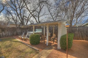 A covered outdoor patio with seating, a grill, and a lamp post. - Leicht Haus Hot-Tub & FirePit 5 blks to Main St! (Fredericksburg)