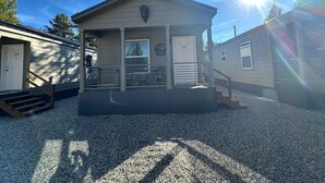 A small, single-story building with a porch, a door labeled '516', and a window with a circular emblem. - 516 - House in West Yellowstone (West Yellowstone)