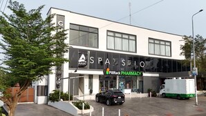 A modern building with a large sign for 'SPASILO PHARMACY'. - Grey Courts (Accra)