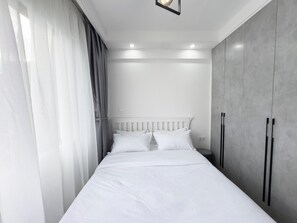Apartamento família, 2 quartos, sacada, vista para a cidade | 2 quartos, cortinas blackout, ferros/tábuas de passar roupa