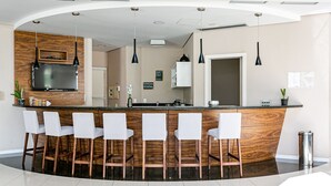A modern kitchen with a central island, bar stools, and pendant lighting. - Gastronomy | Gym | Pool #ITA10 (Florianópolis)