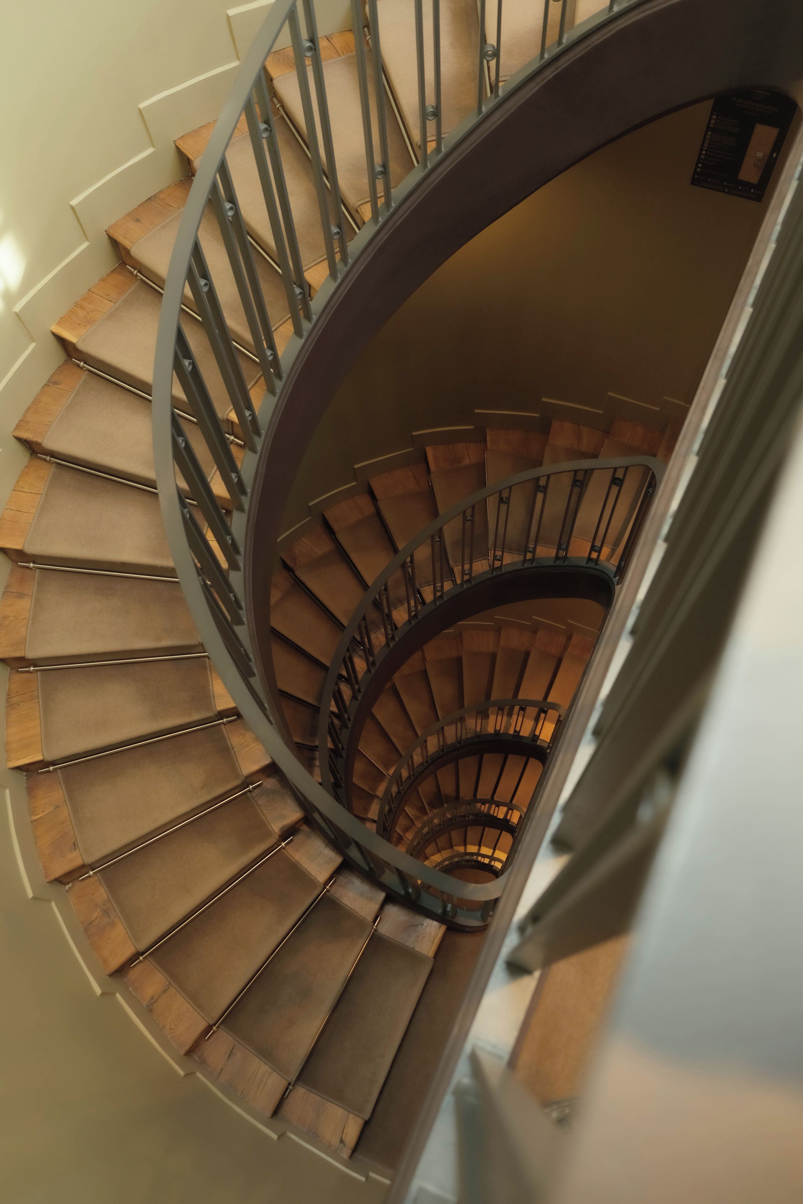 A spiral staircase with wooden steps and metal railings.