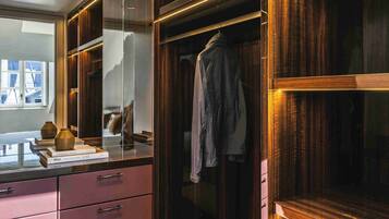 A modern closet with wooden doors, a mirror, and a hanging garment.