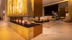 Una sala de estar moderna con una chimenea central, un sofá y una mesa de centro.