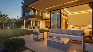 Una casa moderna con un amplio espacio exterior, que incluye un conjunto de sofás y una mesa de centro.
