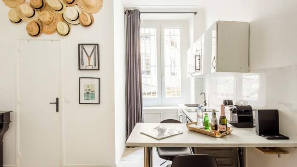 Une cuisine moderne équipée d’une table à manger, d’une machine à café et d’un ordinateur portable.