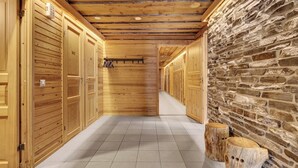 A corridor with wooden lockers and a stone wall. - Bliss Adventure Lodge (Pelkosenniemi)