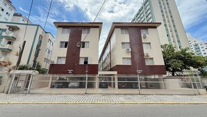 A modern building with a tiled facade, multiple balconies, and a gated entrance. - Feet in the Sand Tupi Beach (Praia Grande)