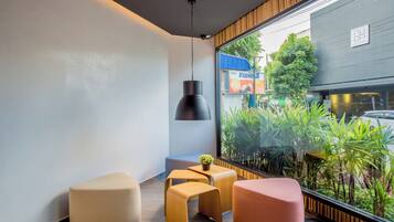 A modern interior with a large window, a hanging pendant light, and a small table with a plant.