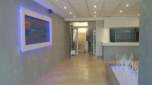 A reception area with a framed sign, a staircase, and a reception desk. - Celadi vista (Rhodes)