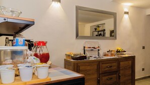 Ein Frühstücksbuffet mit Tassen, einer Kaffeemaschine und einem Spiegel.
