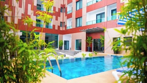 A modern hotel with a swimming pool, outdoor seating, and potted plants. - Hotel KEMAKA (Abidjan)