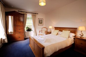 Restful retreat with a large bed, dresser, and table, perfect for a comfortable stay.