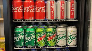A beverage cooler stocked with various sodas and water bottles.