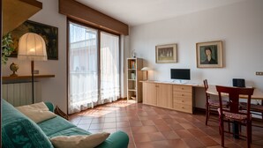 A cozy living room with a sofa, a dining table with chairs, a TV, and a bookshelf. - Apartment with garage near the center of Verona (Verona)