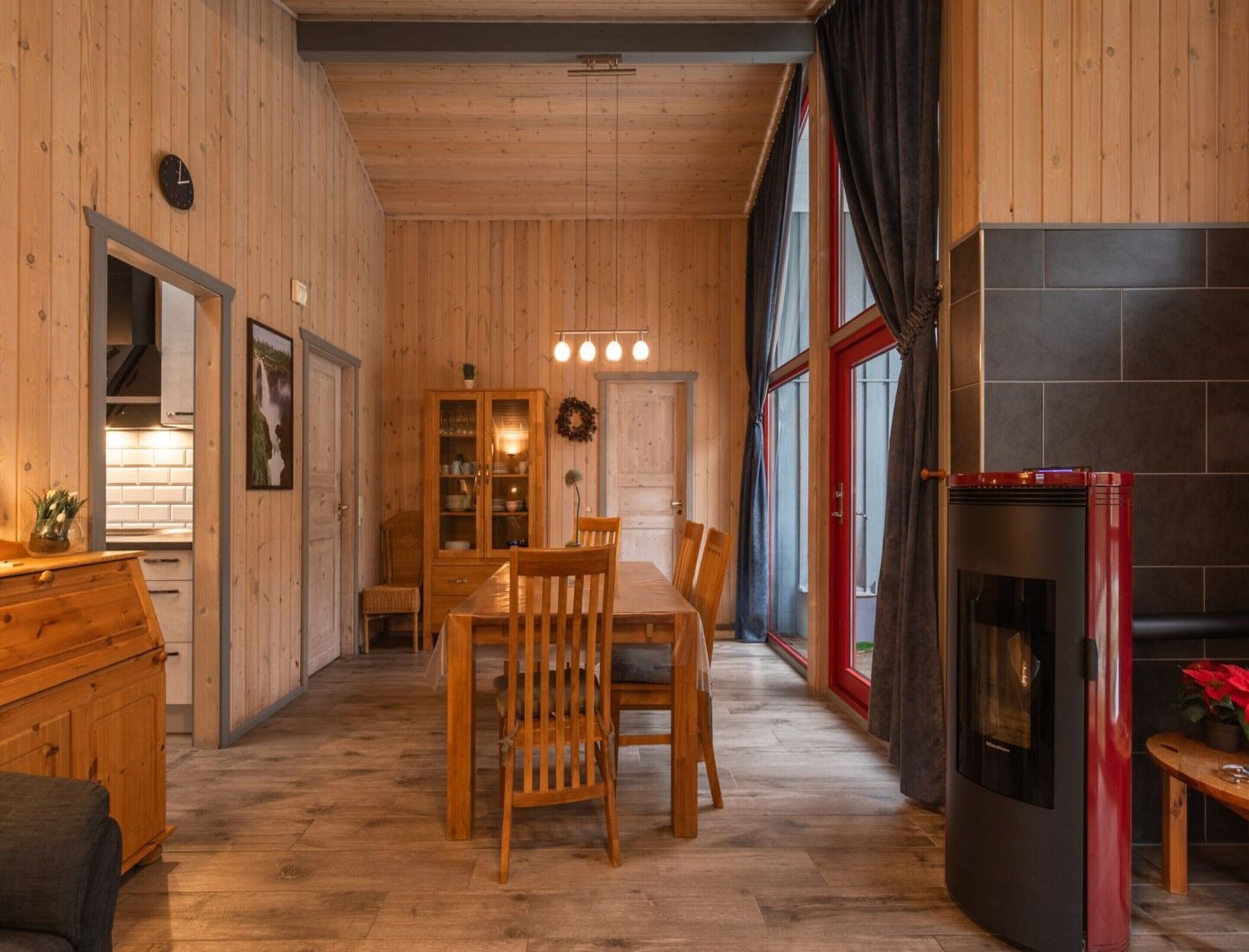 Ein Holzinnenraum mit Essbereich, Kamin und Küche.