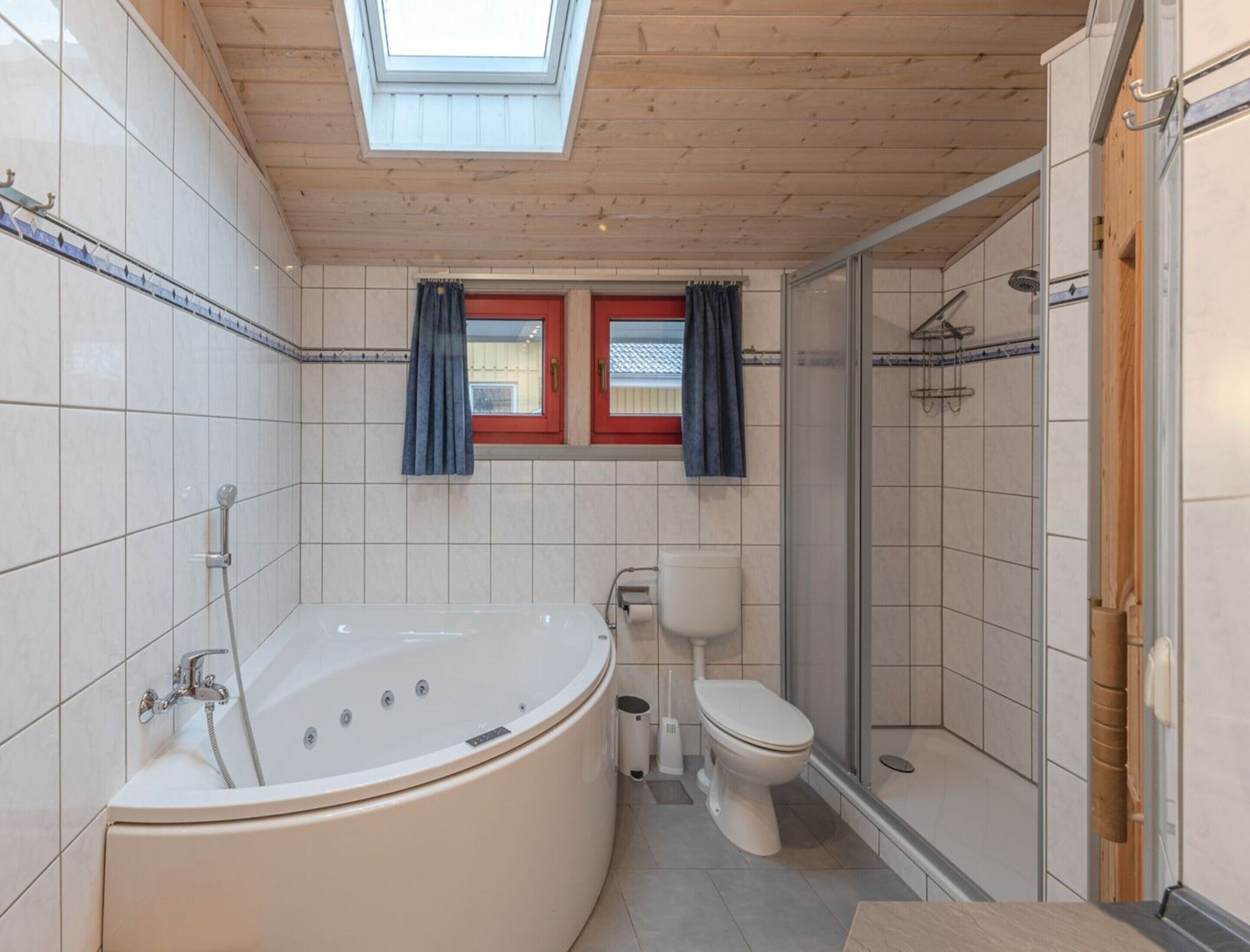 A modern bathroom with a freestanding bathtub, a toilet, and a glass-enclosed shower area.
