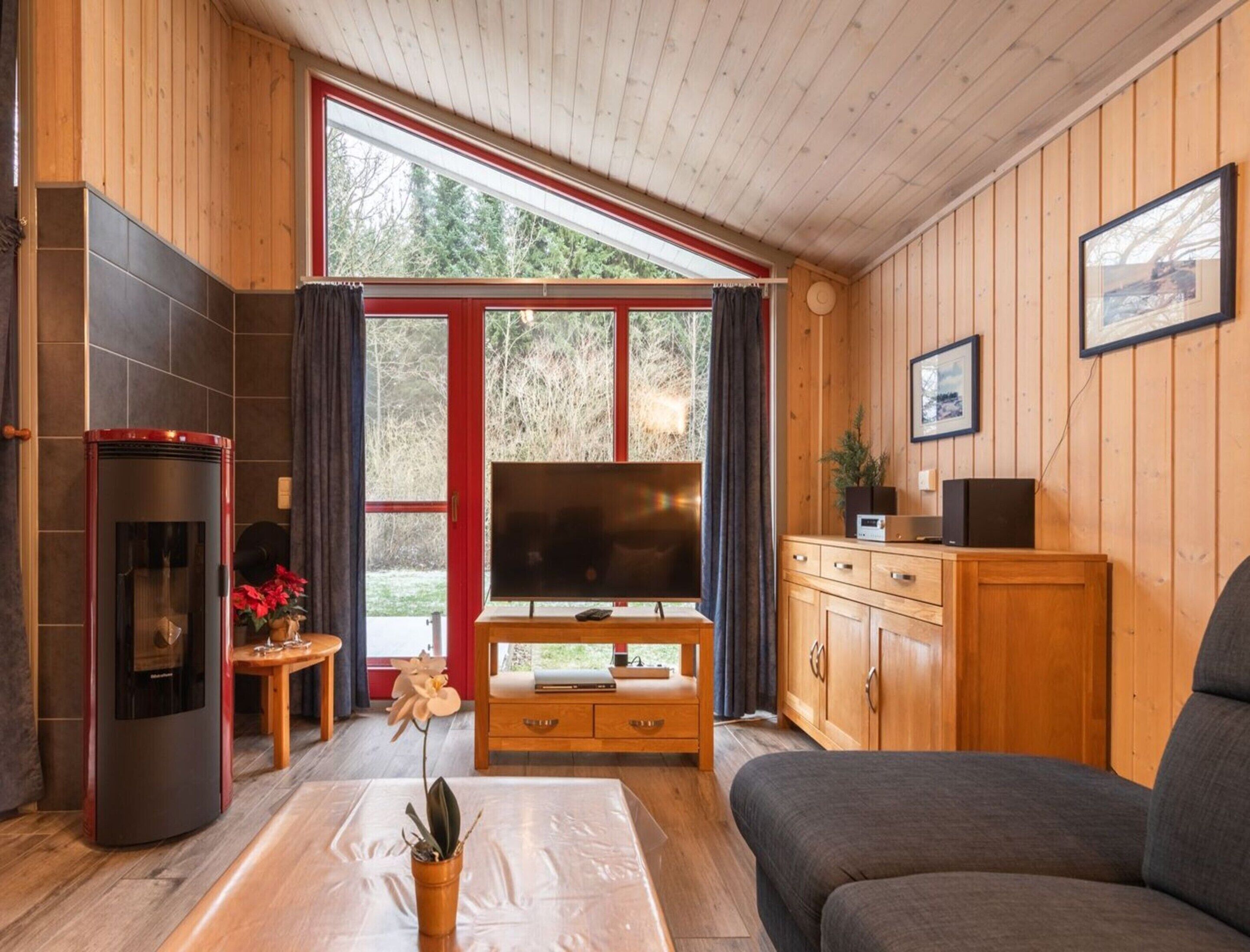 Ein gemütliches Wohnzimmer mit Kamin, Fernseher und einer Couch.