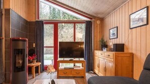 Een gezellige woonkamer met een open haard, een televisie en een bank.