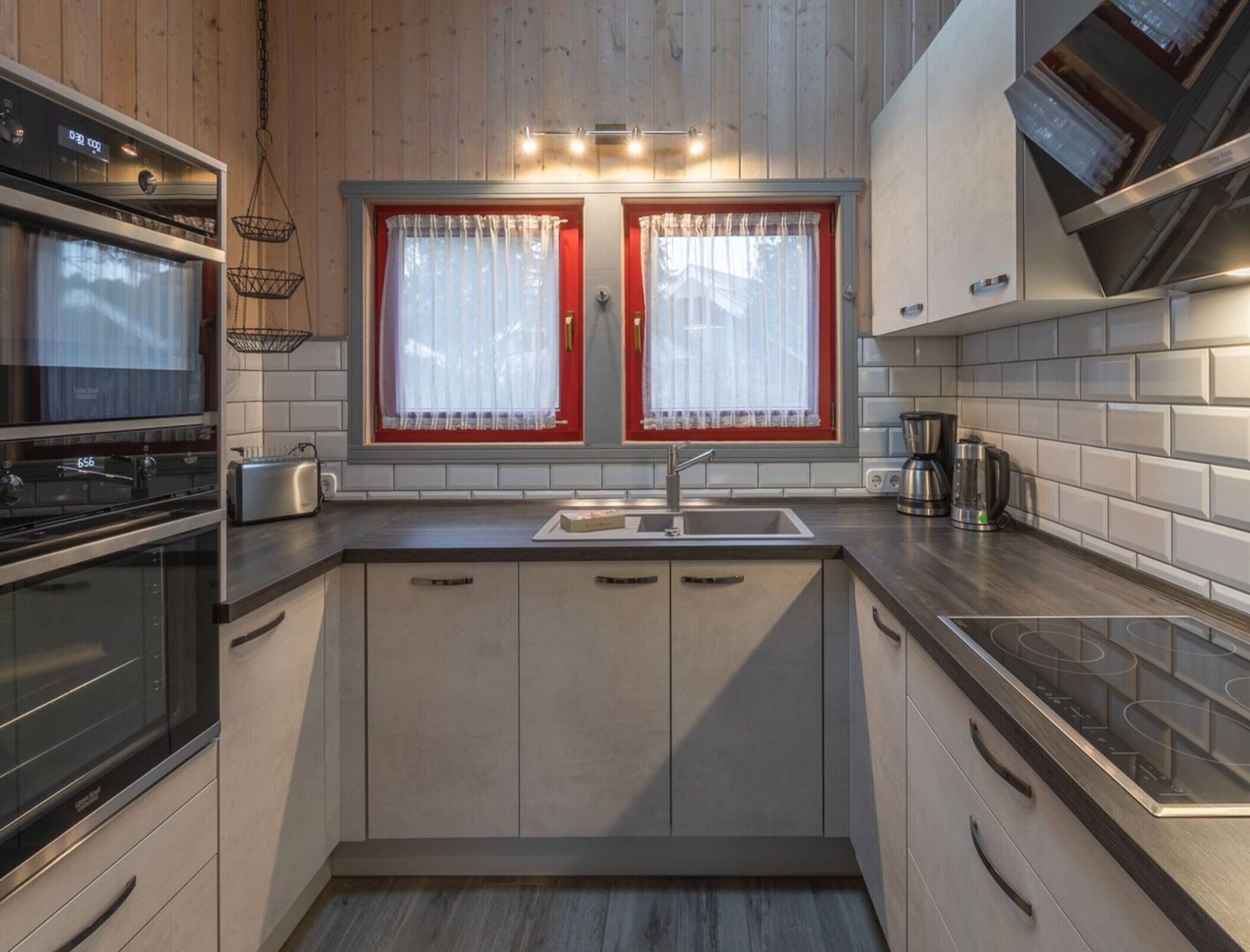 Una cocina moderna con dos hornos, un lavaplatos y una cafetera.