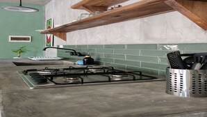 A kitchen with a gas stove, wooden shelves, and a green tiled backsplash. - Charming villa with WiFi and AC, Spa in gorgeous Samaná, 2 minutes from   beach, (Samaná)