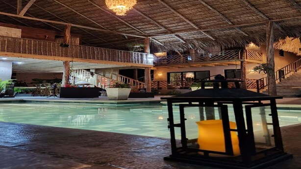 An indoor swimming pool with a thatched roof, a staircase, and a lantern. - Charming villa with WiFi and AC, Spa in gorgeous Samaná, 2 minutes from   beach, (Samaná)